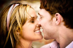 young couple smiling while about to kiss